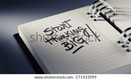 Closeup of a personal agenda setting an important date representing a time schedule. The words Start thinking BIG written on a white notebook to remind you an important appointment.
