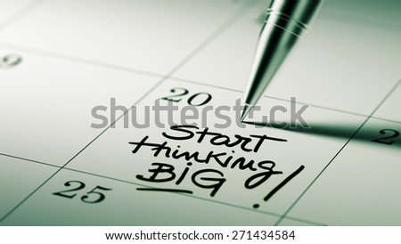 Closeup of a personal agenda setting an important date written with pen. The words Start thinking BIG written on a white notebook to remind you an important appointment.