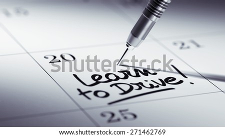 Concept image of a Calendar with a golden dart stick. The words Learn to Drive written on a white notebook to remind you an important appointment.