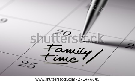 Closeup of a personal agenda setting an important date written with pen. The words Family Time written on a white notebook to remind you an important appointment.