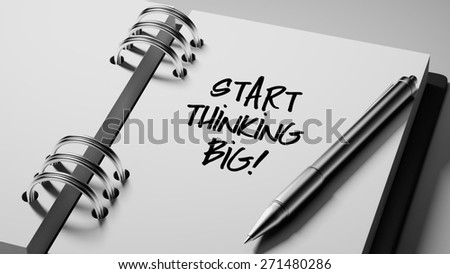 Closeup of a personal agenda setting an important date writing with pen. The words Start thinking BIG written on a white notebook to remind you an important appointment.