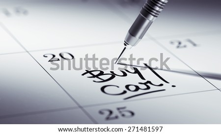 Concept image of a Calendar with a golden dart stick. The words Buy Car written on a white notebook to remind you an important appointment.