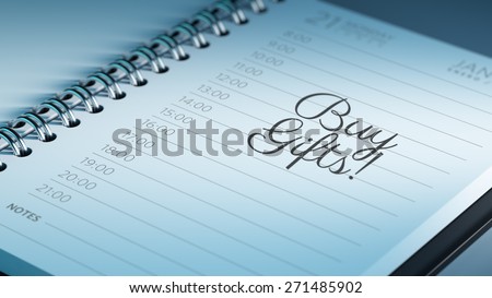 Closeup of a personal calendar setting an important date representing a time schedule. The words Buy Gifts written on a white notebook to remind you an important appointment.