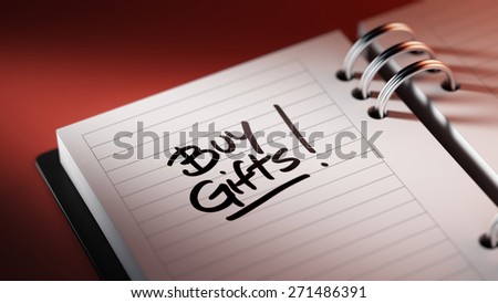 Closeup of a personal agenda setting an important date representing a time schedule. The words Buy Gifts written on a white notebook to remind you an important appointment.