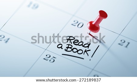Concept image of a Calendar with a red push pin. Closeup shot of a thumbtack attached. The words Read a book written on a white notebook to remind you an important appointment.
