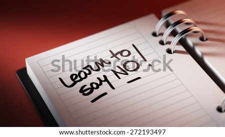 Closeup of a personal agenda setting an important date representing a time schedule. The words Learn to say no written on a white notebook to remind you an important appointment.