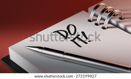 Closeup of a personal agenda setting an important date writing with pen. The words Do it written on a white notebook to remind you an important appointment.
