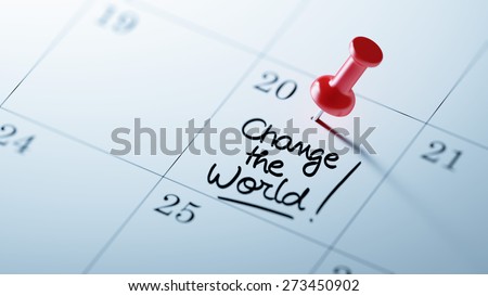 Concept image of a Calendar with a red push pin. Closeup shot of a thumbtack attached. The words Change the world written on a white notebook to remind you an important appointment.