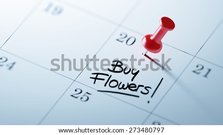 Concept image of a Calendar with a red push pin. Closeup shot of a thumbtack attached. The words Buy Flowers written on a white notebook to remind you an important appointment.