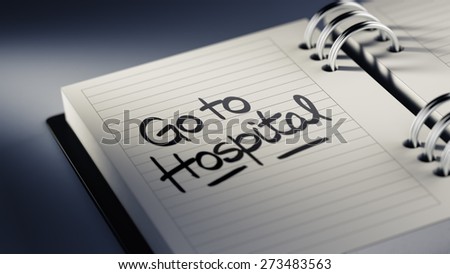 Closeup of a personal agenda setting an important date representing a time schedule. The words Go to Hospital written on a white notebook to remind you an important appointment.