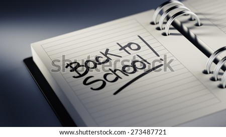 Closeup of a personal agenda setting an important date representing a time schedule. The words Back to school written on a white notebook to remind you an important appointment.