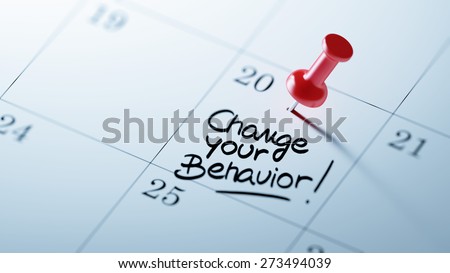 Concept image of a Calendar with a red push pin. Closeup shot of a thumbtack attached. The words Change your behavior written on a white notebook to remind you an important appointment.