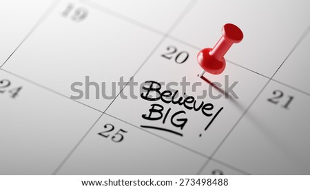 Concept image of a Calendar with a red push pin. Closeup shot of a thumbtack attached. The words Believe BIG written on a white notebook to remind you an important appointment.