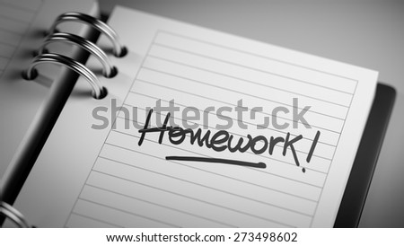 Closeup of a personal agenda setting an important date representing a time schedule. The words Homework written on a white notebook to remind you an important appointment.