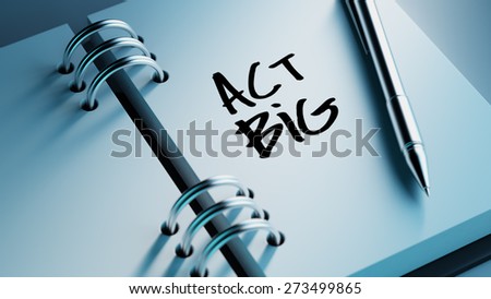 Closeup of a personal agenda setting an important date writing with pen. The words Act BIG written on a white notebook to remind you an important appointment.