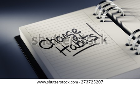 Closeup of a personal agenda setting an important date representing a time schedule. The words Change Habits written on a white notebook to remind you an important appointment.