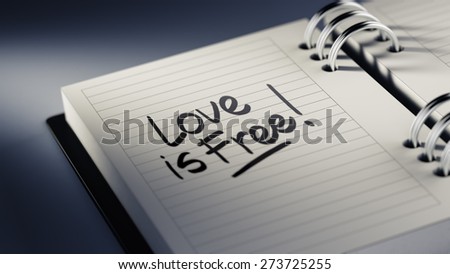 Closeup of a personal agenda setting an important date representing a time schedule. The words Love is Free written on a white notebook to remind you an important appointment.