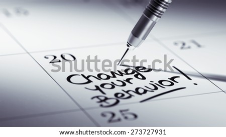Concept image of a Calendar with a golden dart stick. The words Change your behavior written on a white notebook to remind you an important appointment.