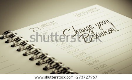Closeup of a personal calendar setting an important date representing a time schedule. The words Change your behavior written on a white notebook to remind you an important appointment.