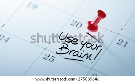 Concept image of a Calendar with a red push pin. Closeup shot of a thumbtack attached. The words Use your Brain written on a white notebook to remind you an important appointment.