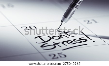 Concept image of a Calendar with a golden dart stick. The words Don't Stress written on a white notebook to remind you an important appointment.