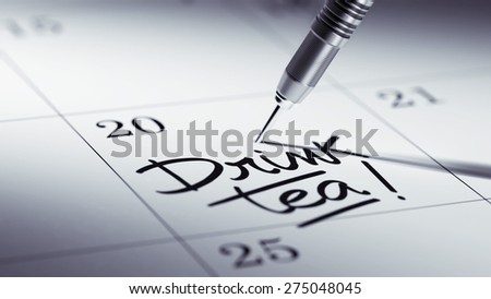 Concept image of a Calendar with a golden dart stick. The words Drink Tea written on a white notebook to remind you an important appointment.