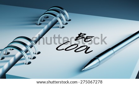 Closeup of a personal agenda setting an important date writing with pen. The words Be cool written on a white notebook to remind you an important appointment.