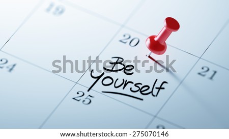 Concept image of a Calendar with a red push pin. Closeup shot of a thumbtack attached. The words be yourself written on a white notebook to remind you an important appointment.