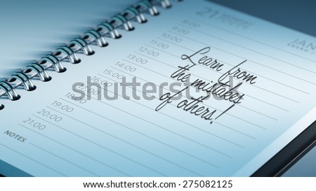Closeup of a personal calendar setting an important date representing a time schedule. The words Learn from the mistakes of others written on a white notebook to remind you an appointment.