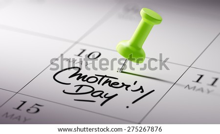 Concept image of a Calendar with a green push pin. Closeup shot of a thumbtack attached. The words Mother\'s Day written on a white notebook to remind you an important appointment.