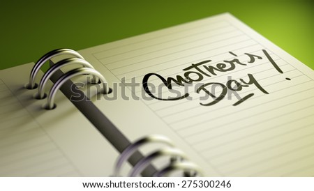 Closeup of a personal agenda setting an important date representing a time schedule. The words Mother\'s Day written on a white notebook to remind you an important appointment.