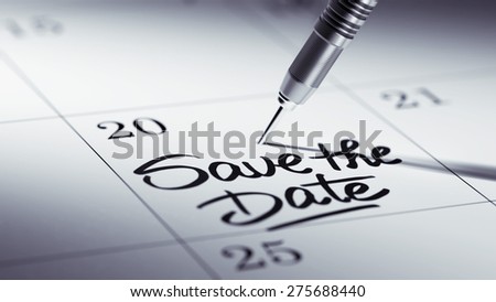 Concept image of a Calendar with a golden dart stick. The words Save the date written on a white notebook to remind you an important appointment.