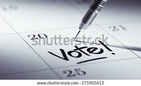 Concept image of a Calendar with a golden dart stick. The words Vote! written on a white notebook to remind you an important appointment.