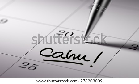 Closeup of a personal agenda setting an important date written with pen. The words Calm written on a white notebook to remind you an important appointment.