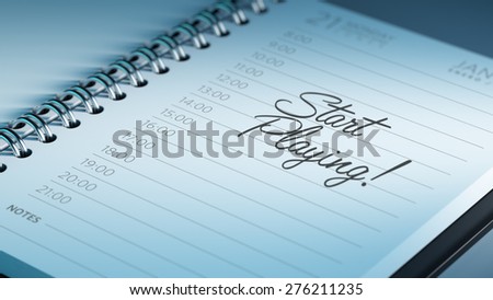 Closeup of a personal calendar setting an important date representing a time schedule. The words Start Playing written on a white notebook to remind you an important appointment.