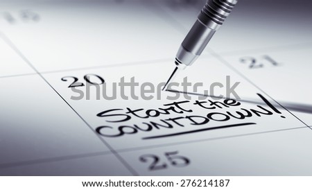 Concept image of a Calendar with a golden dart stick. The words Start Countdown written on a white notebook to remind you an important appointment.