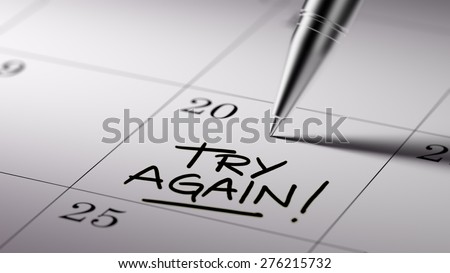 Closeup of a personal agenda setting an important date written with pen. The words Try Again written on a white notebook to remind you an important appointment.