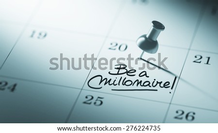 Concept image of a Calendar with a push pin. Closeup shot of a thumbtack attached. The words Be a millionaire written on a white notebook to remind you an important appointment.