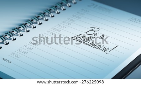 Closeup of a personal calendar setting an important date representing a time schedule. The words Be a millionaire written on a white notebook to remind you an important appointment.