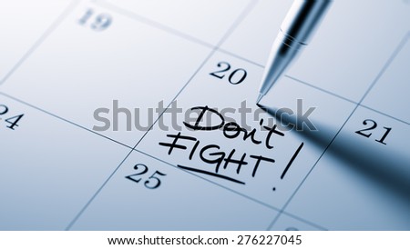 Closeup of a personal agenda setting an important date written with pen. The words Don\'t Fight written on a white notebook to remind you an important appointment.
