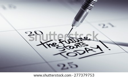 Concept image of a Calendar with a golden dart stick. The words The future starts today written on a white notebook to remind you an important appointment.