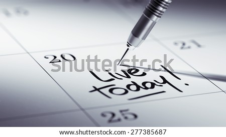 Concept image of a Calendar with a golden dart stick. The words Live today written on a white notebook to remind you an important appointment.