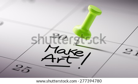 Concept image of a Calendar with a green push pin. Closeup shot of a thumbtack attached. The words Make Art written on a white notebook to remind you an important appointment.