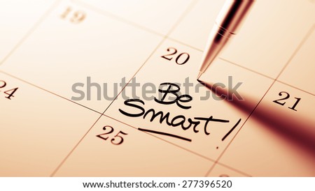 Closeup of a personal agenda setting an important date written with pen. The words Be Smart written on a white notebook to remind you an important appointment.
