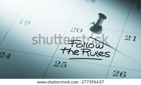Concept image of a Calendar with a push pin. Closeup shot of a thumbtack attached. The words Follow the rules written on a white notebook to remind you an important appointment.
