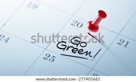 Concept image of a Calendar with a red push pin. Closeup shot of a thumbtack attached. The words Go Green written on a white notebook to remind you an important appointment.
