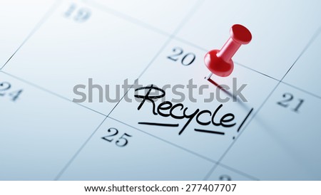 Concept image of a Calendar with a red push pin. Closeup shot of a thumbtack attached. The words Recycle written on a white notebook to remind you an important appointment.