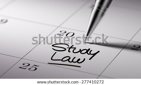 Closeup of a personal agenda setting an important date written with pen. The words Study Law written on a white notebook to remind you an important appointment.
