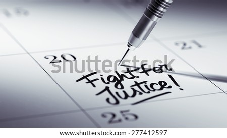 Concept image of a Calendar with a golden dart stick. The words Fight for Justice written on a white notebook to remind you an important appointment.