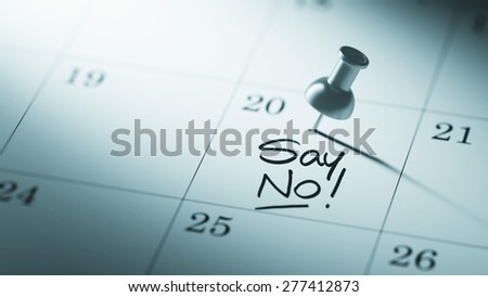 Concept image of a Calendar with a push pin. Closeup shot of a thumbtack attached. The words Say NO written on a white notebook to remind you an important appointment.